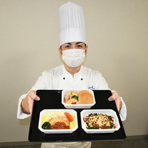成田ならではの返礼品として用意された機内食セットのハンバーグや白身魚フライを紹介する末シェフ＝成田市
