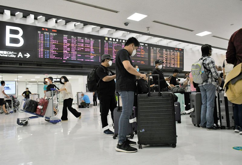 訪日観光団体ツアーの外国人客らが行き交う成田空港の国際線到着ロビー＝７日