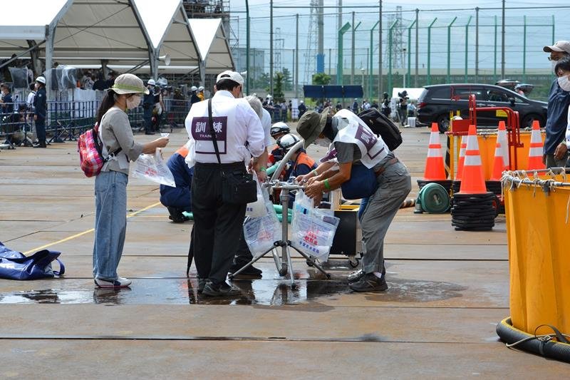 仮設の給水栓を接続し、応急的な給水活動の訓練を行う自主防災組織のメンバーら＝１日、千葉市中央区
