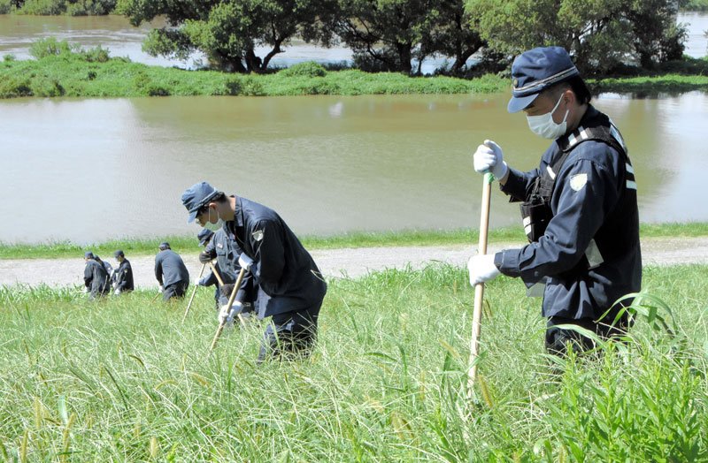 南さんのものとみられる靴と靴下が発見された江戸川の河川敷で捜索にあたる県警の捜査員＝２５日午後０時１０分ごろ、流山市