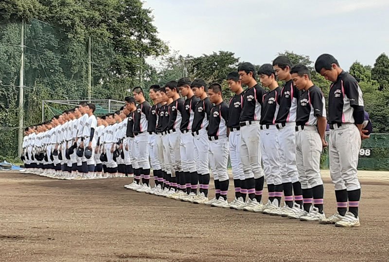 追悼式で黙祷する佐倉高（手前）と千葉黎明高の選手たち=２２日、佐倉市の佐倉高グラウンド