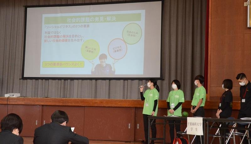 松尾高の生徒に地域活性化への取り組みを紹介する千葉商科大の学生ら＝山武市
