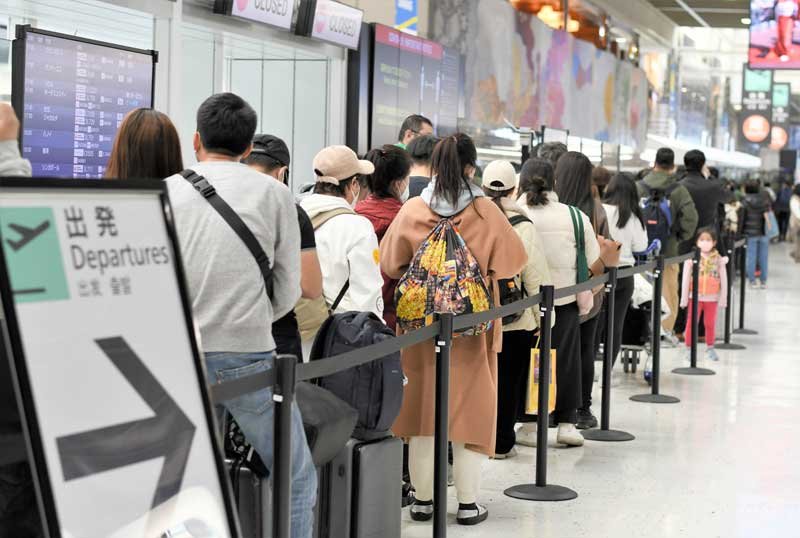 出国ラッシュが始まった成田空港で、保安検査場で行列をつくる旅客＝２８日午後、成田市