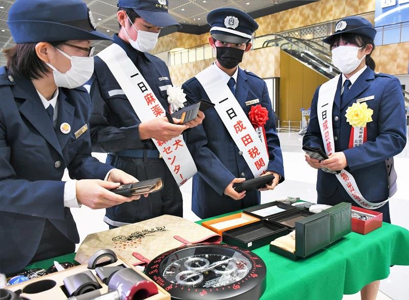 精巧に作られた偽のブランド品を手に取る中学生＝成田空港
