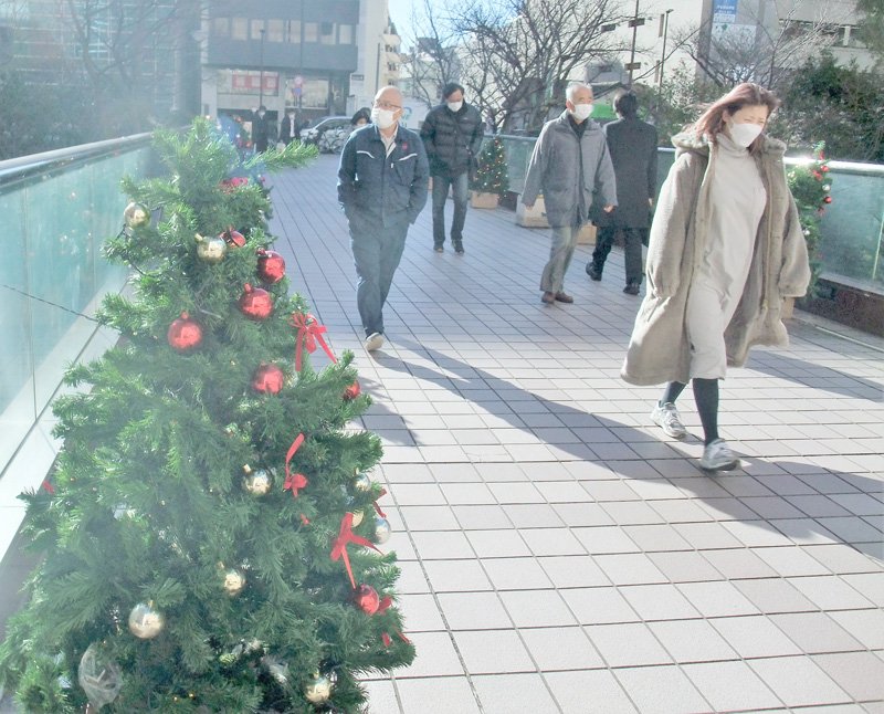 時折強い風が吹く中、ＪＲ千葉駅近くを歩く通行人＝２３日、千葉市中央区