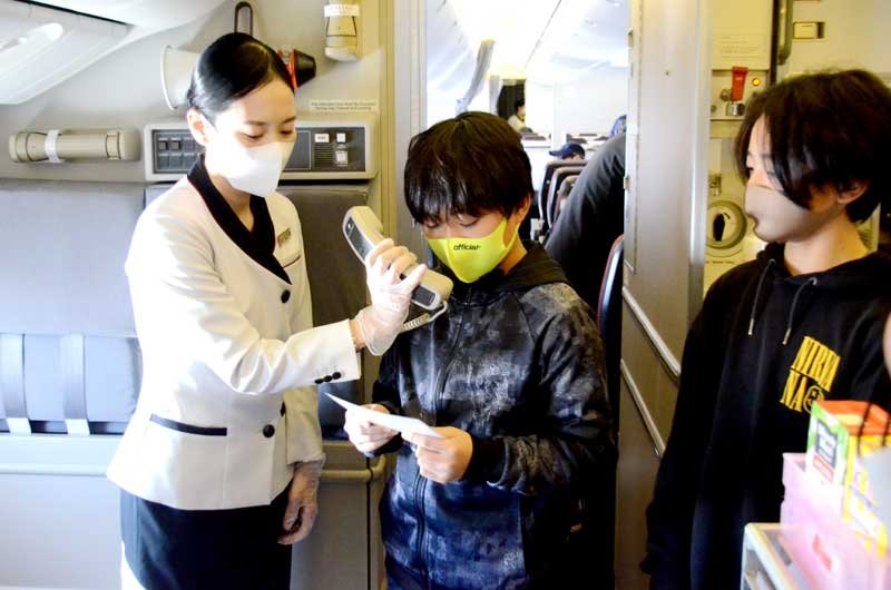 成田空港発着の周遊フライト便で、機内アナウンスを体験する児童＝１７日