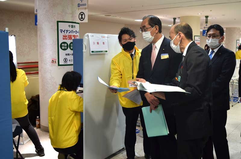 千葉市の出張窓口を視察する松本大臣（右から３人目）＝２３日、千葉市中央区のそごう千葉店