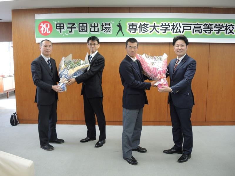 杉山由祥・市議会議長（右端）から花束を受け取る専大松戸野球部の大森主将（右から２人目）＝２４日、松戸市役所
