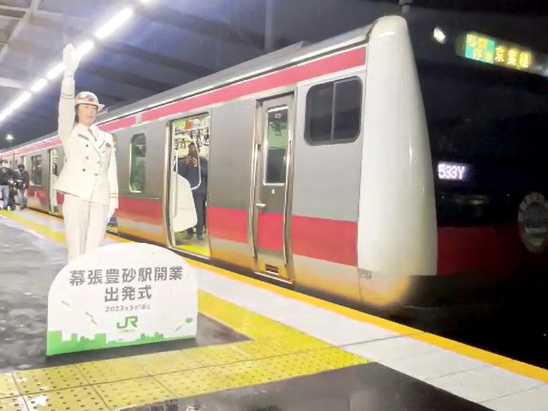 前原奈緒子海浜幕張駅長の合図で蘇我行き電車が幕張豊砂駅を発車した＝１８日午前５時６分ごろ、千葉市美浜区