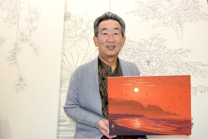 旭市の海を描いた絵画を手にする椎名保さん＝旭市