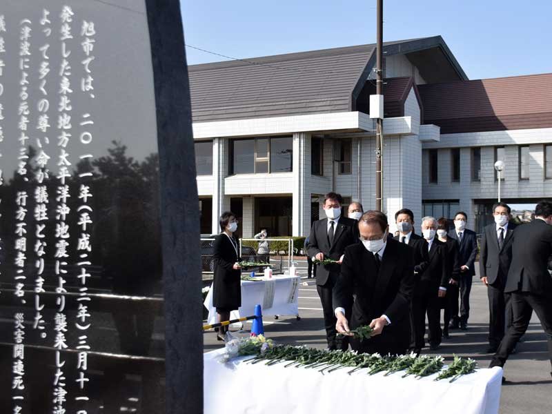 黙とう後に慰霊碑に献花する米本弥一郎市長（手前）＝１１日、旭市横根のいいおかユートピアセンター