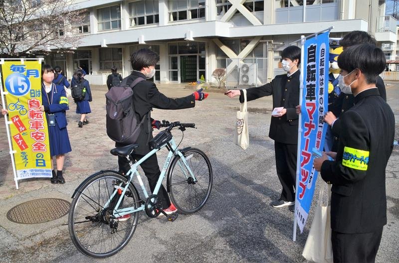 自転車で通学してきた生徒にチラシなどを配る風紀委員の１年生＝２０日、千葉市中央区の県立千葉南高校
