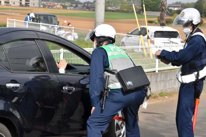 通行禁止違反者に事情を聴く佐倉署員＝１４日午前８時１０分ごろ、八街市