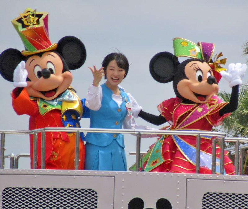パレードで手を振るミッキーとミニー。中央は東京ディズニーリゾート・アンバサダーの小笠原美果さん＝２９日、浦安市

