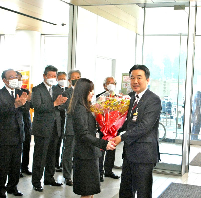 ４期目初日の登庁で職員から花束を受け取る宮本市長（右）＝２７日、習志野市役所
