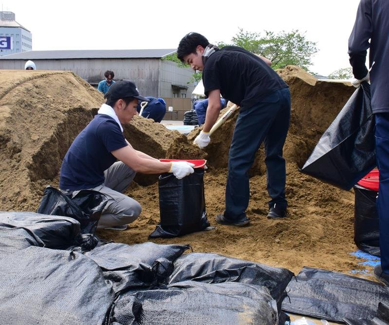 水害に備え土のうを作る新規採用職員＝茂原市