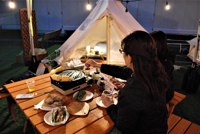 船橋東武の屋上にオープンしたバーベキュー施設で、大型連休期間にキャンプ気分を味わう女性客ら＝船橋市
