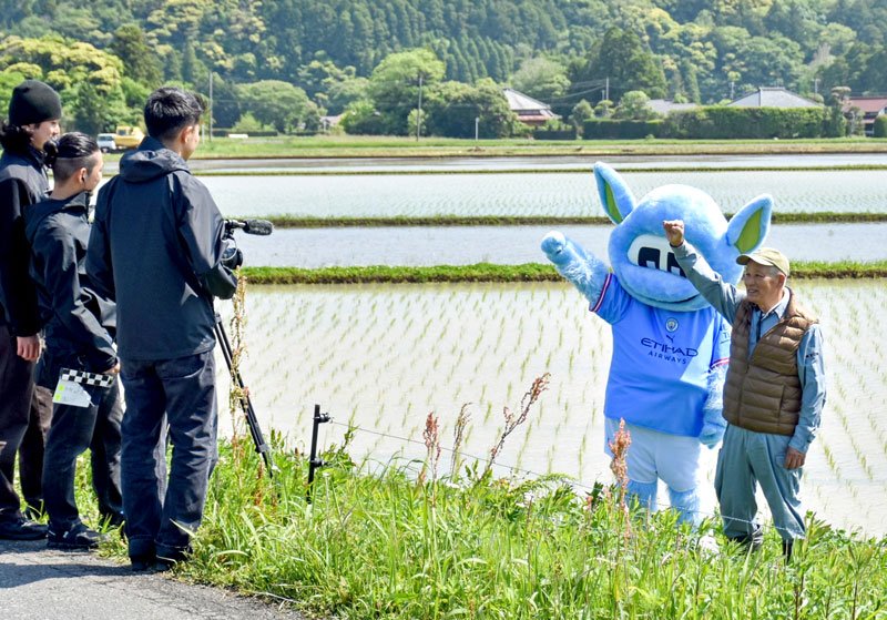 田んぼで動画撮影をするムーンチェスターと藤平社長＝いすみ市