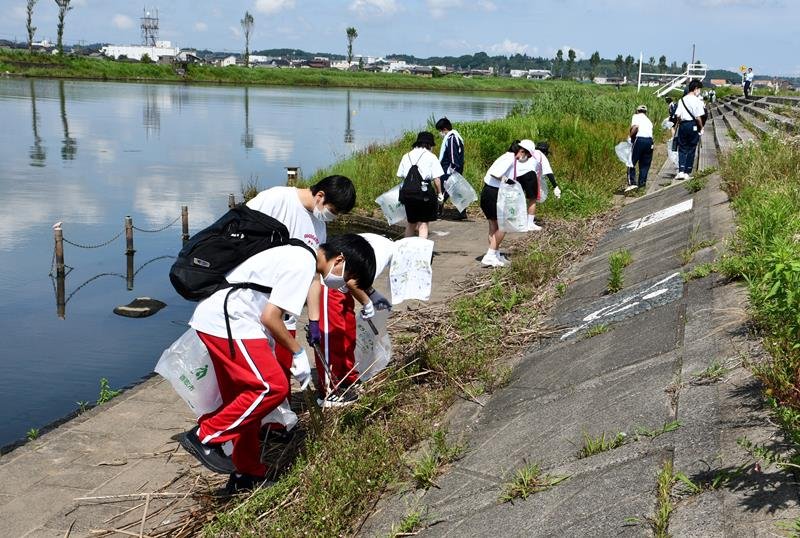 黒部川周辺でごみ拾いを行う生徒ら＝２４日、香取市
