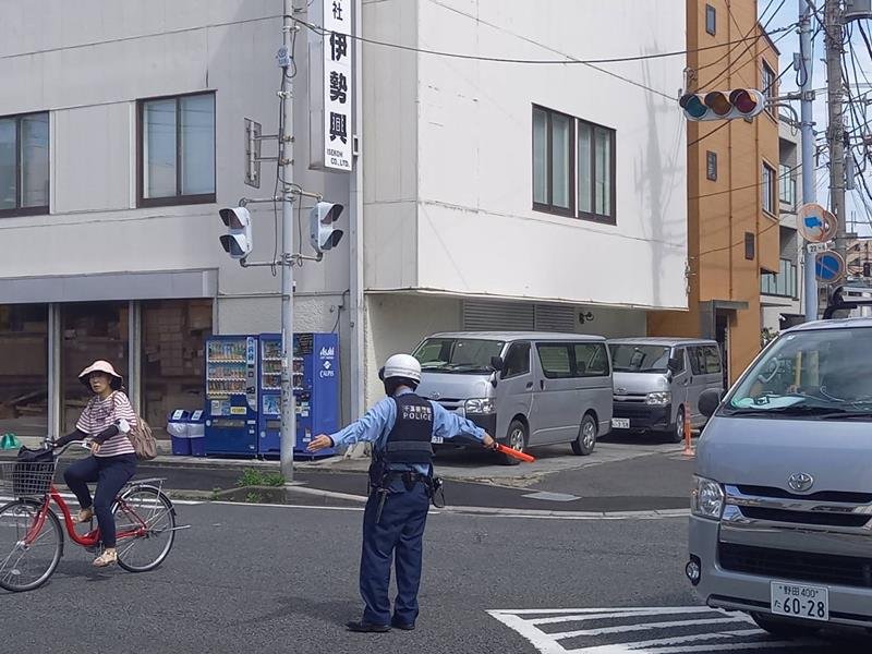 停電が発生し止まった信号機の前で交通誘導する警察官＝３０日午後２時半ごろ、市川市湊新田