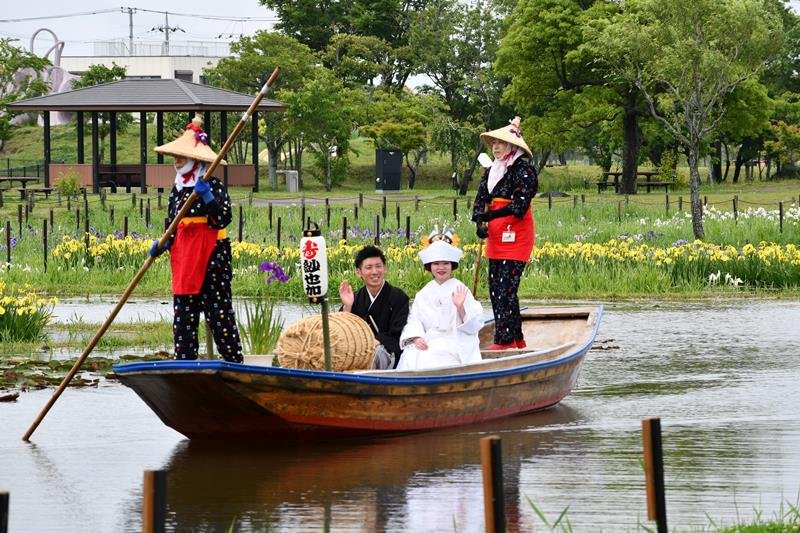 来園者の祝福に手を振る新郎新婦＝３日、香取市の水郷佐原あやめパーク
