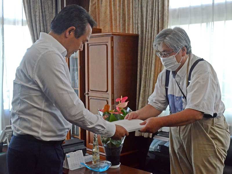 金坂市長（左）に署名簿を手渡す新倉さん＝１８日、大網白里市役所