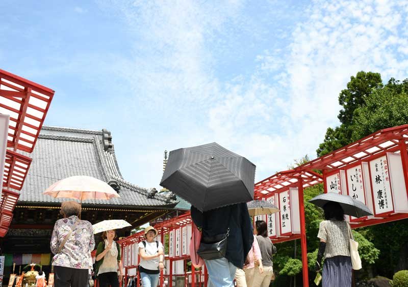 厳しい暑さの中、日傘を差す参拝客が歩く成田山新勝寺境内＝７日午後、成田市