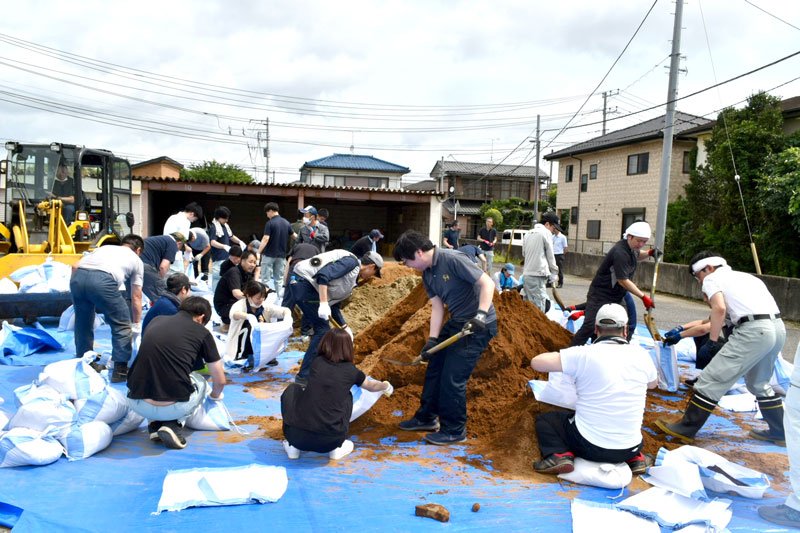 グループに分かれて土のうを作る職員＝八街市役所第３庁舎裏駐車場