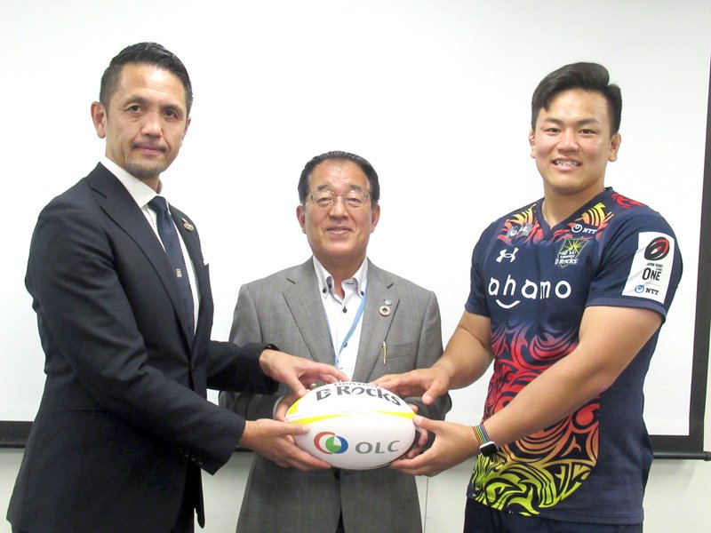 ラグビーボールを贈った「浦安Ｄ－Ｒｏｃｋｓ」の下沖社長（左）と武内慎選手（右）。中央は鈴木教育長＝浦安市役所
