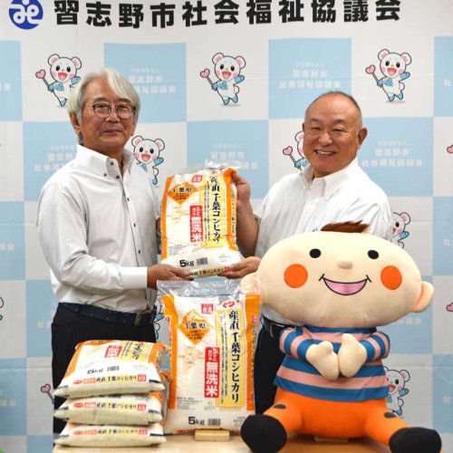 熊崎理事長（右）からコメを受け取る習志野市社会福祉協議会の高橋会長＝１８日、習志野市社会福祉協議会