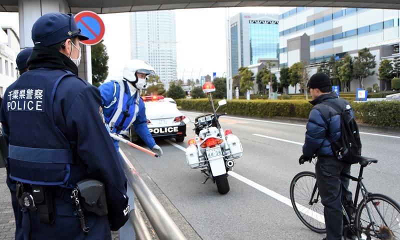 自転車利用者に安全運転を呼びかける警察官＝２月、千葉市美浜区
