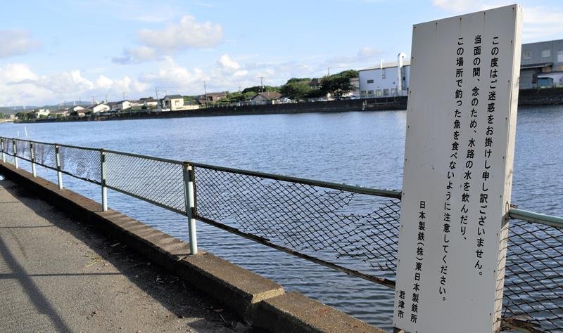 小糸川沿いに設置した看板で、日本製鉄などは釣った魚を食べないよう呼びかけている＝８日、君津市
