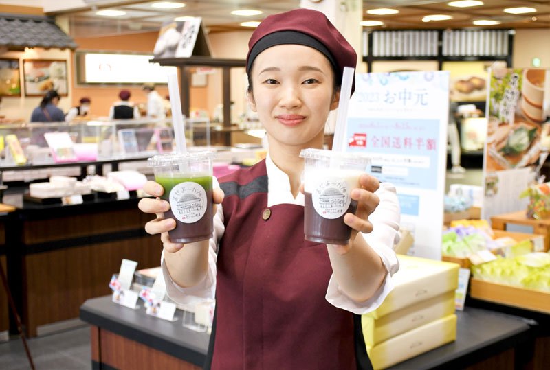 和菓子が多く陳列された米屋の総本店の中で食べ歩き商品「まぜよ～かん」を紹介するスタッフ＝成田市