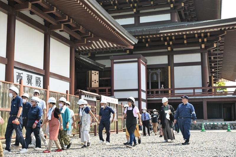 成田山新勝寺の職員の誘導で大本堂から避難する訓練参加者＝５日、成田市

