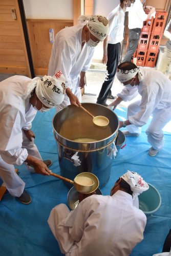出来上がったお神酒を一升瓶に移す氏子総代たち＝１５日、南房総市
