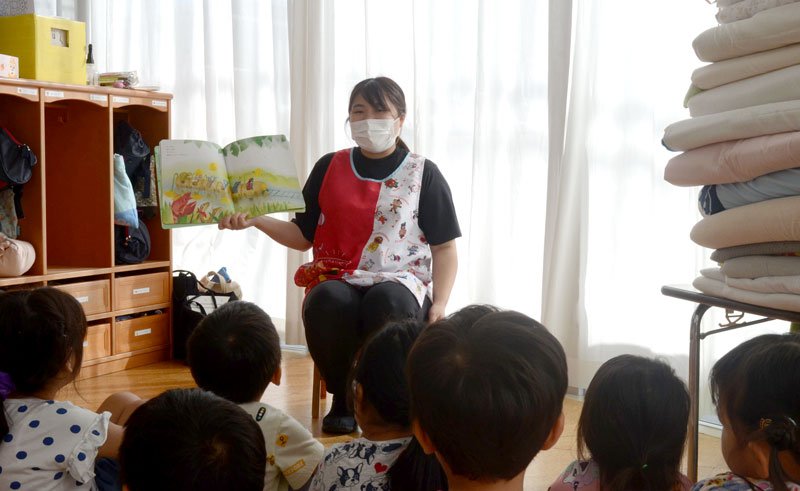 １２日ぶりに再開した大竹保育園で、園児に絵本を読み聞かせる職員＝１９日、大網白里市大竹