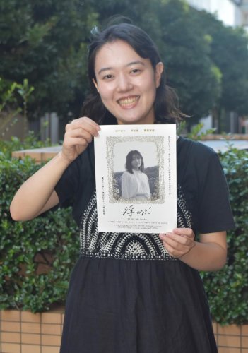 映画「浮かぶ」のチラシを持つ吉田監督＝市川市
