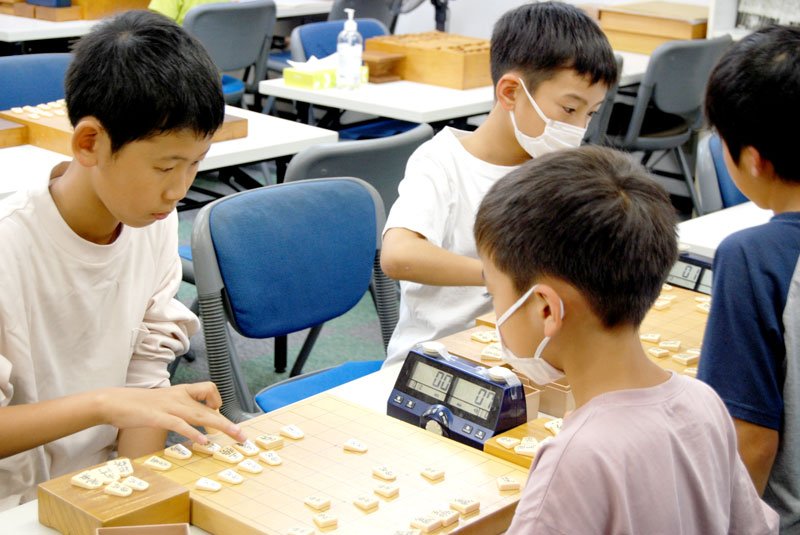 真剣な面持ちで将棋盤に向かう子どもたち＝１２日午後６時半ごろ、八千代市勝田台の「Ｃ＆Ｃ勝田台将棋センター」