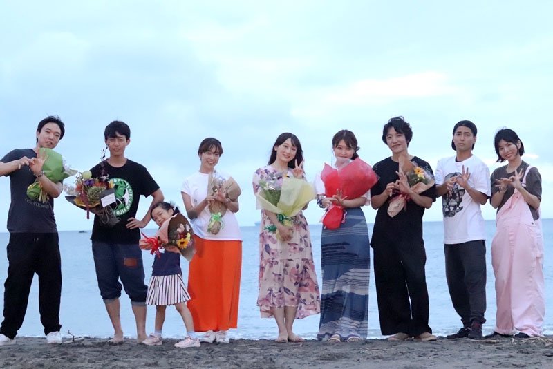 撮影を終え、鋸南町の海岸でポーズを決めるキャストら（同町提供）