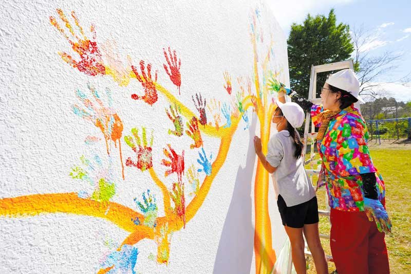 手形アートで体育倉庫カラフルに　勝浦・総野小　「ハッピーツリー」バルサミコヤスさんが下絵