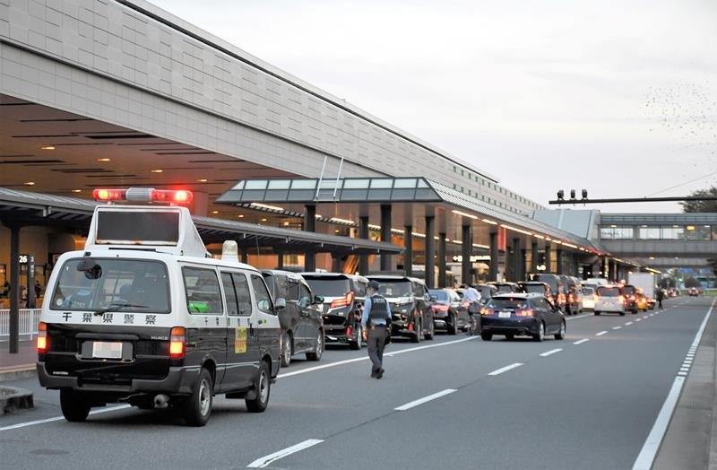 成田空港の乗降場を利用する車があふれ、走行車線をふさぐ「二重駐車」をしないよう呼びかける警察官ら＝成田市（画像は一部加工してあります）