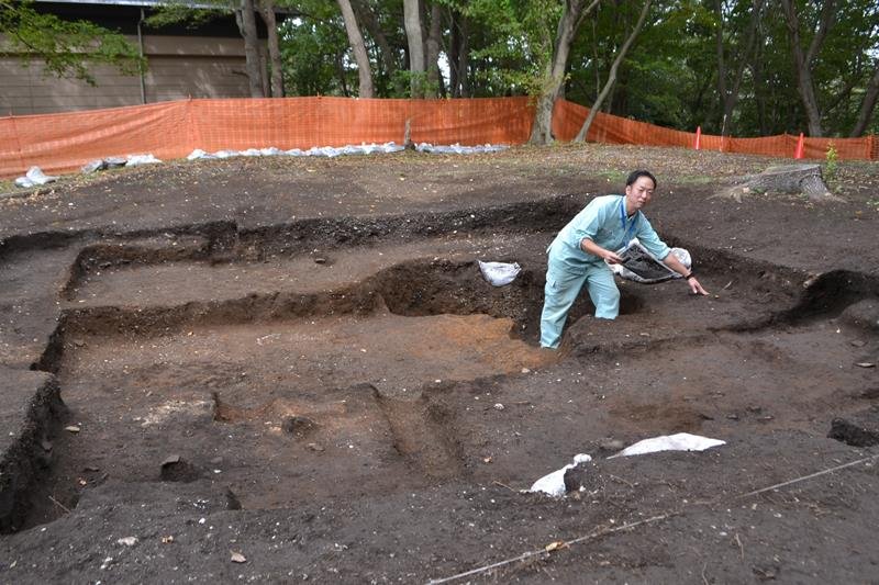 縄文時代後期の竪穴住居跡が確認された北貝塚で、「硬化面」を説明する市教委の担当者＝千葉市若葉区
