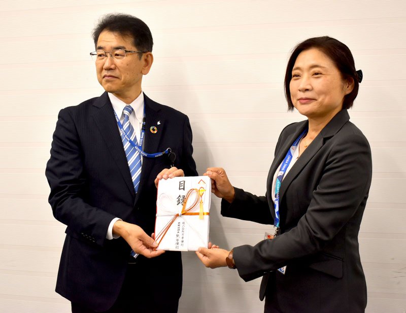 高梨みちえ健康福祉部長（右）に目録を渡した吉田稔執行役員＝２５日、千葉市中央区