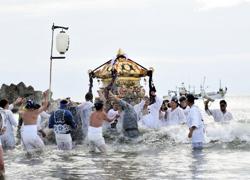 若い衆に担がれ勇壮に海を進む神社のみこし＝８日、旭市
