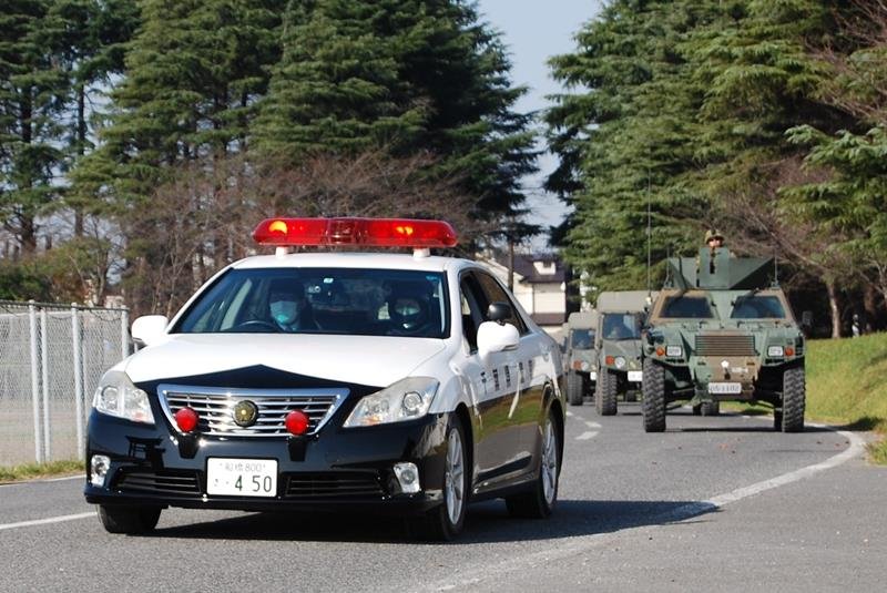 陸自の車両を誘導する県警のパトカー＝船橋市の陸上自衛隊習志野演習場
