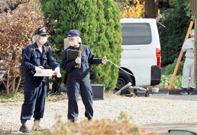 ２人の遺体が見つかった住宅敷地内を調べる警察官＝６日午前１０時５分ごろ、佐倉市
