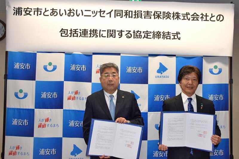 協定書を持つ内田市長（左）と井上理事＝浦安市
