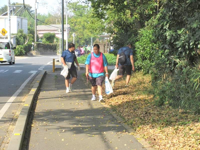 歩きながら、道端でごみを拾い集める参加者＝市原市（市原市スポーツ協会提供）