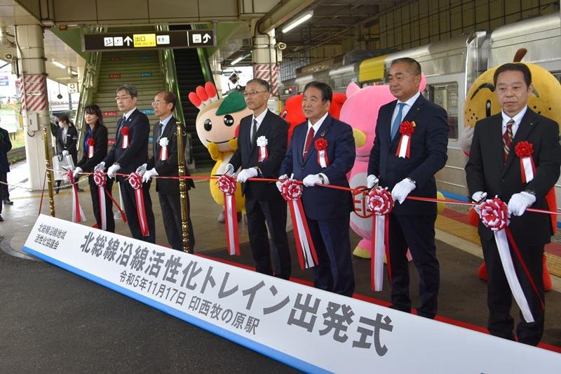 各首長らが出席した沿線地域をＰＲする全面広告付き電車「北総線沿線活性化トレイン」の出発式＝１７日、印西市の印西牧の原駅
