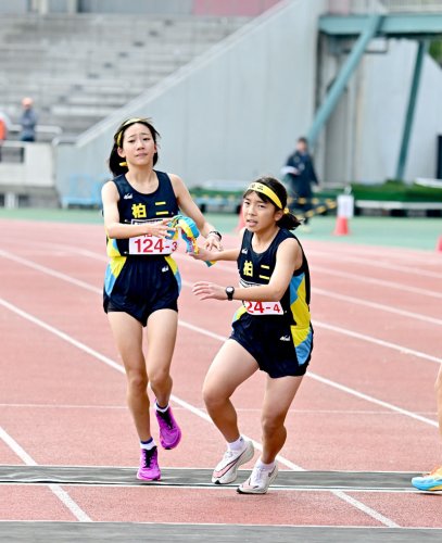 たすきをつなぐ女子柏二の３区の渡辺董子（左）と小林真穂＝柏の葉
